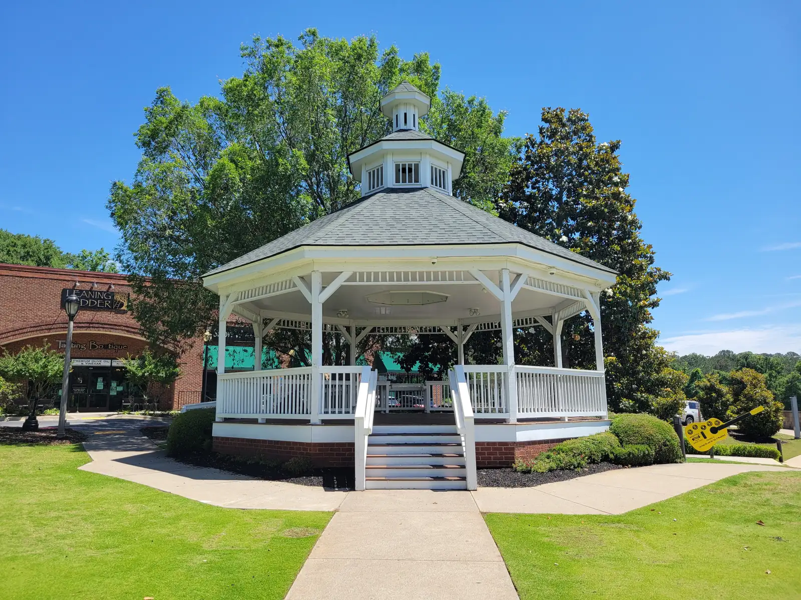 A white gazebo on a lawn in downtown Woodstock