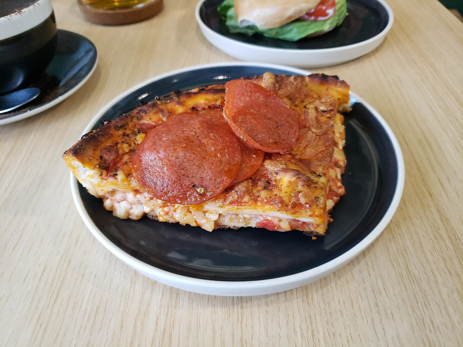 A slice of deep-pan pepperoni pizza on a plate. The photo was not taken at a Woodstock restaurant.