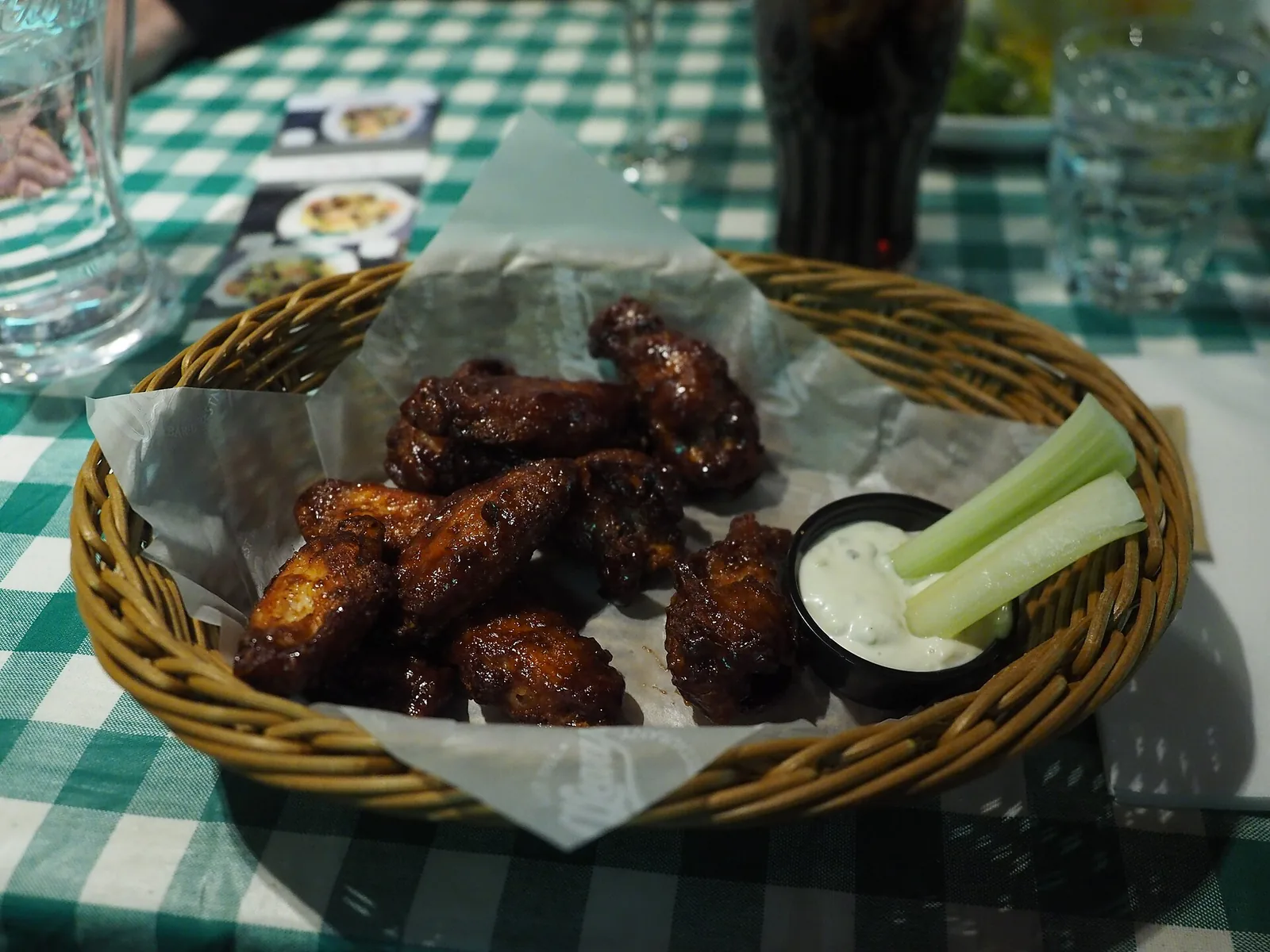 A basket of chicken wings in hot sauce with a dip and celery sticks. The photo was not taken at a Woodstock restaurant.